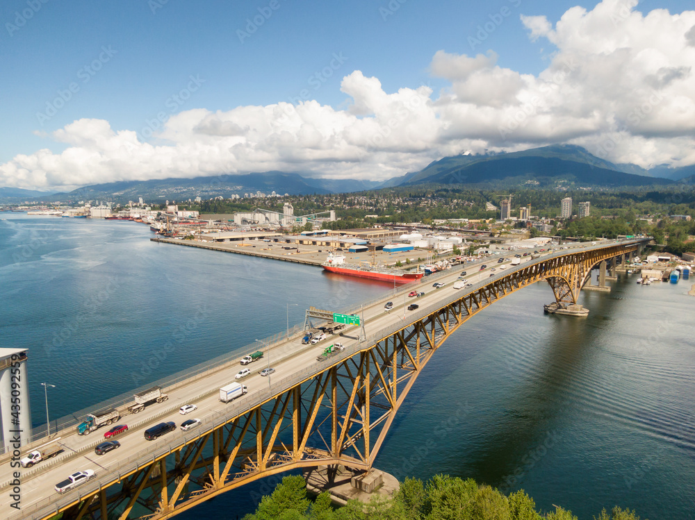 Aerial view of an Industrial Site and Second Narrows Bridge during a sunny spring day. Taken in Vancouver, British Columbia, Canada.