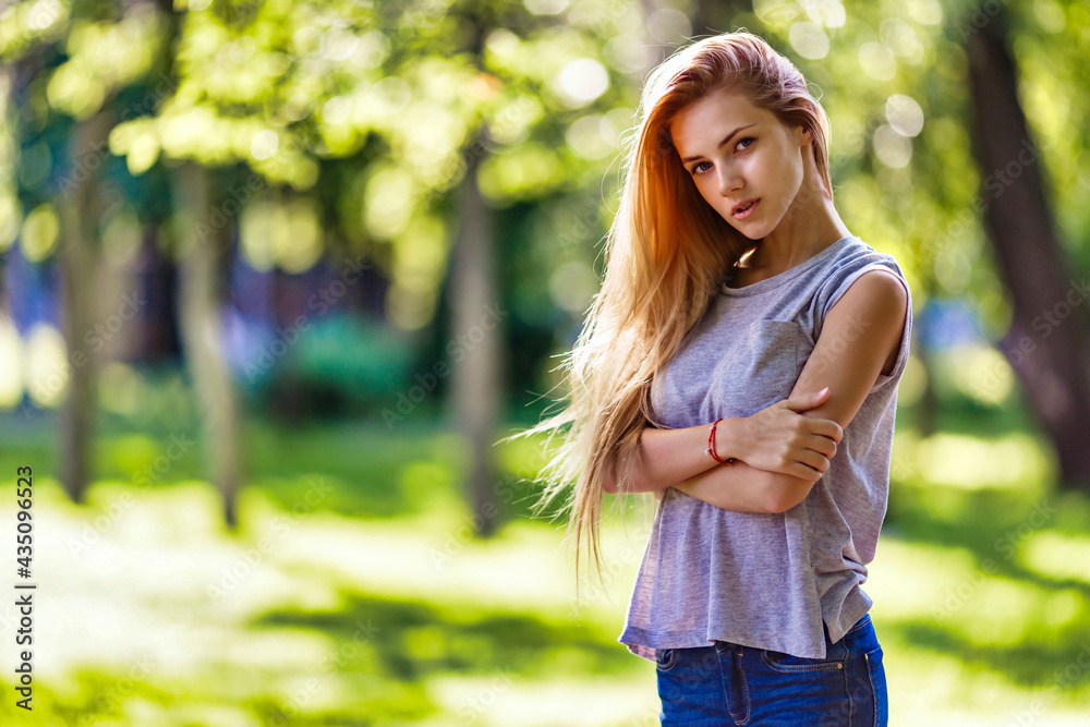 Beautiful, slender girl walks in the park, dressed in a sporty style Beautiful, slender girl walks in the park, dressed in a sporty style