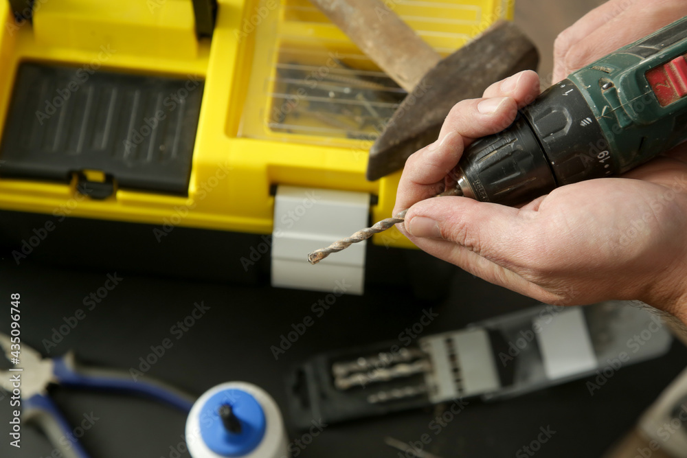 Handyman changing drill bit on a cordless drill Handyman changing drill bit on a cordless drill