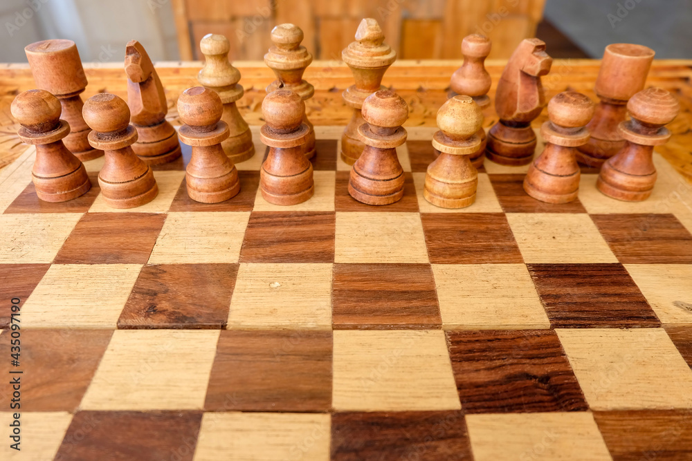 Wooden chess boards and white chess pieces with typical Balinese carvings. Standby for battle. Wooden chess boards and white chess pieces with typical Balinese carvings. Standby for battle.