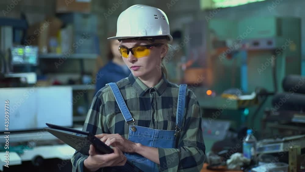 A female engineer-manager in a protective helmet inspects the plant with a digital tablet A female engineer-manager in a protective helmet inspects the plant with a digital tablet