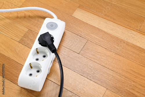 White extension cord with three outlets. Power strip with switch for home or office.