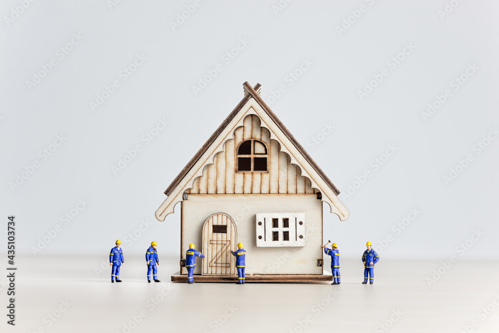 Figurines of builders working on the house. Developing concept Figurines of builders working on the house. Developing concept