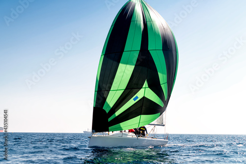 Sport sailing boat with a striped sail