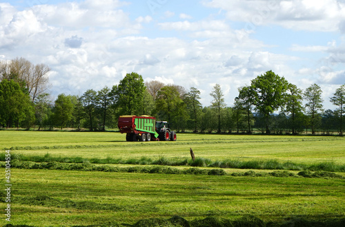 Traktor mit Ladewagen auf einer Wiese  Landwirtschaft