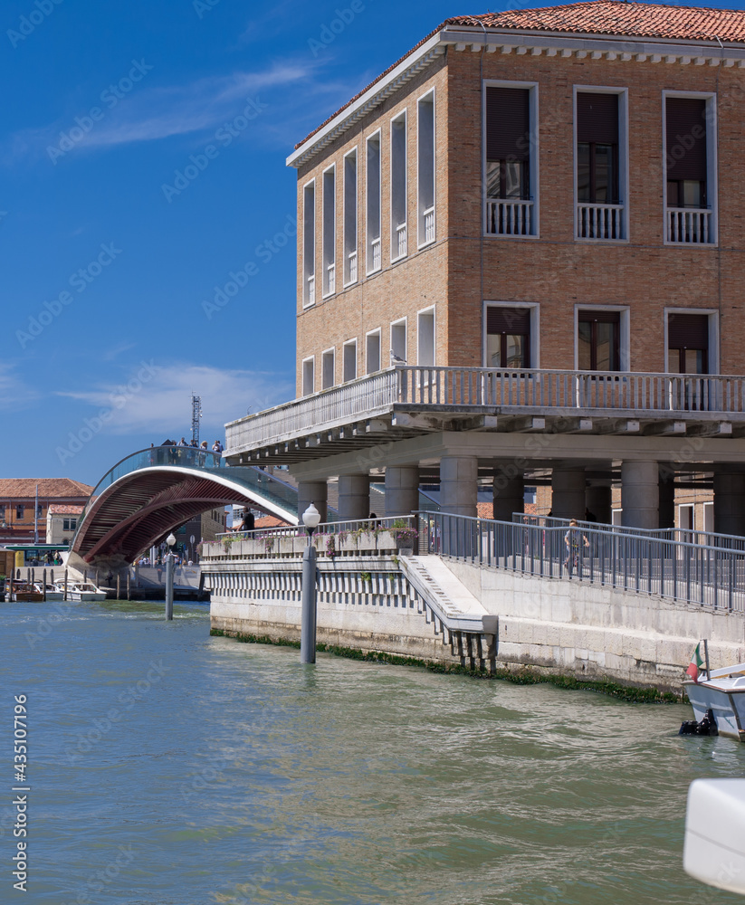modern bridge facades facing blue clean waters of busy grand canal of Venice