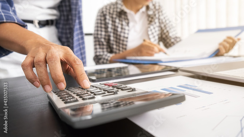 Business woman using calculator to calculate business data  accountancy document at home office.