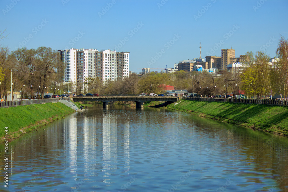 landscape with water canal and distant houses behind the bridge in kharkiv, Ukraine
