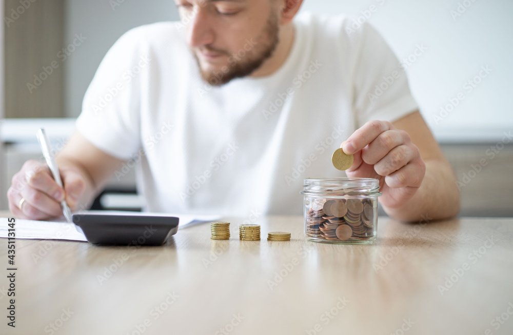 Business man putting coin in glass bottle saving bank and account for his money all in finance accounting concept. Business man putting coin in glass bottle saving bank and account for his money all in finance accounting concept.
