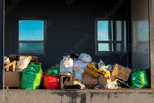 Packaged waste for landfilling. Garbage bags and boxes on the loading dock. Waste removal.