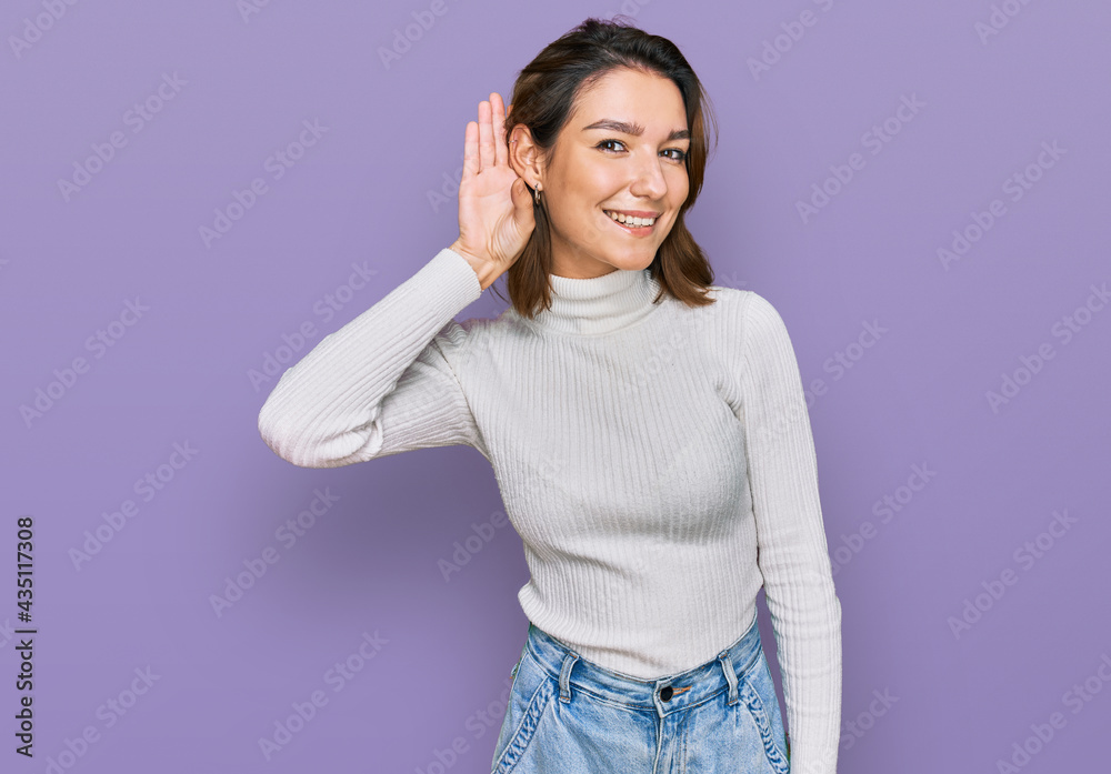 Young caucasian girl wearing casual clothes smiling with hand over ear listening an hearing to rumor or gossip. deafness concept. Young caucasian girl wearing casual clothes smiling with hand over ear listening an hearing to rumor or gossip. deafness concept.