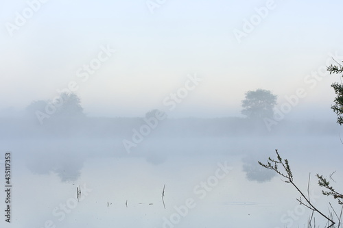 Dense morning fog over the river in late spring