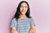 Hispanic teenager girl with dental braces wearing casual clothes happy face smiling with crossed arms looking at the camera. positive person.