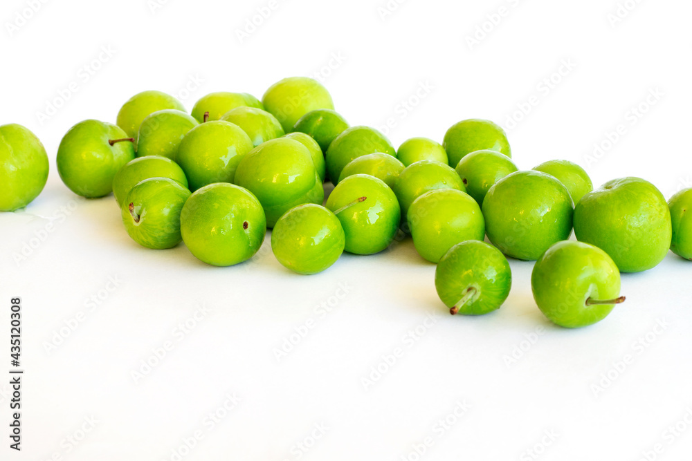 Pile of green plum fruit isolated on white
