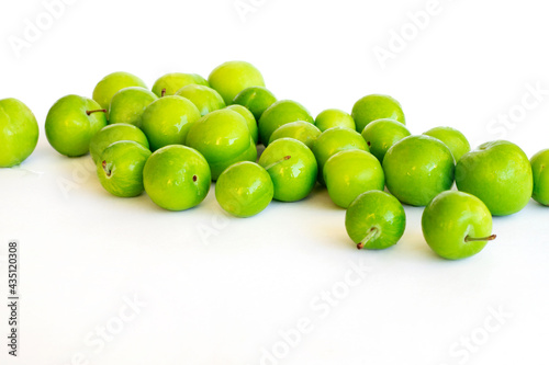 Pile of green plum fruit isolated on white photo