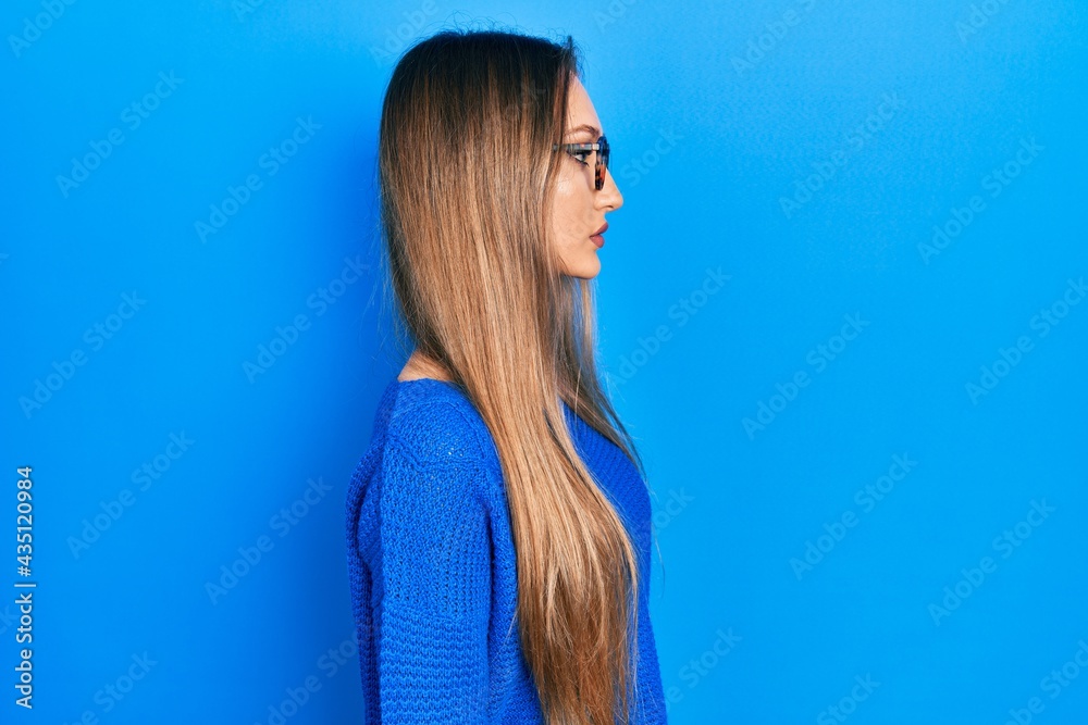 Young blonde girl wearing casual clothes and glasses looking to side, relax profile pose with natural face with confident smile. Young blonde girl wearing casual clothes and glasses looking to side, relax profile pose with natural face with confident smile.