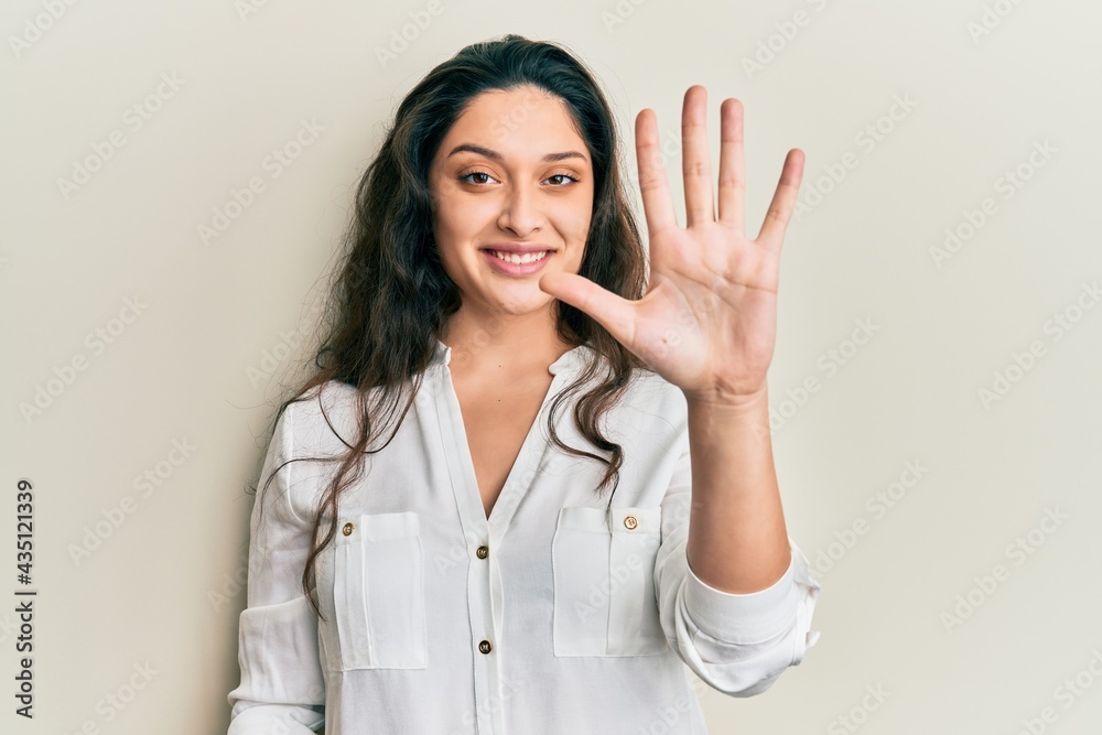 Beautiful middle eastern woman wearing casual clothes showing and pointing up with fingers number five while smiling confident and happy. Beautiful middle eastern woman wearing casual clothes showing and pointing up with fingers number five while smiling confident and happy.