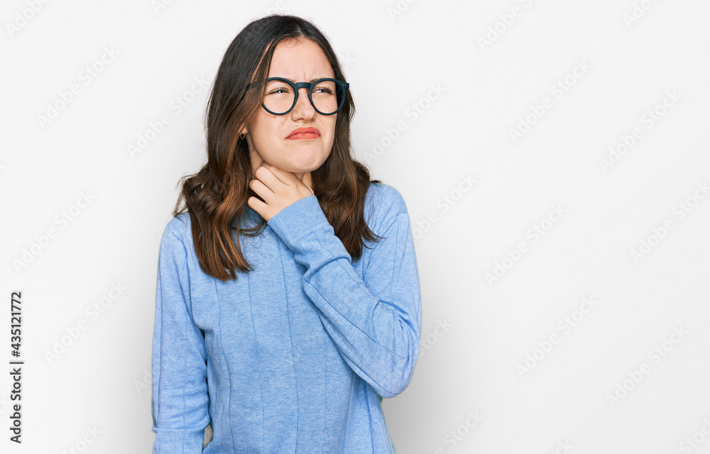 Young beautiful woman wearing casual clothes and glasses touching painful neck, sore throat for flu, clod and infection Young beautiful woman wearing casual clothes and glasses touching painful neck, sore throat for flu, clod and infection