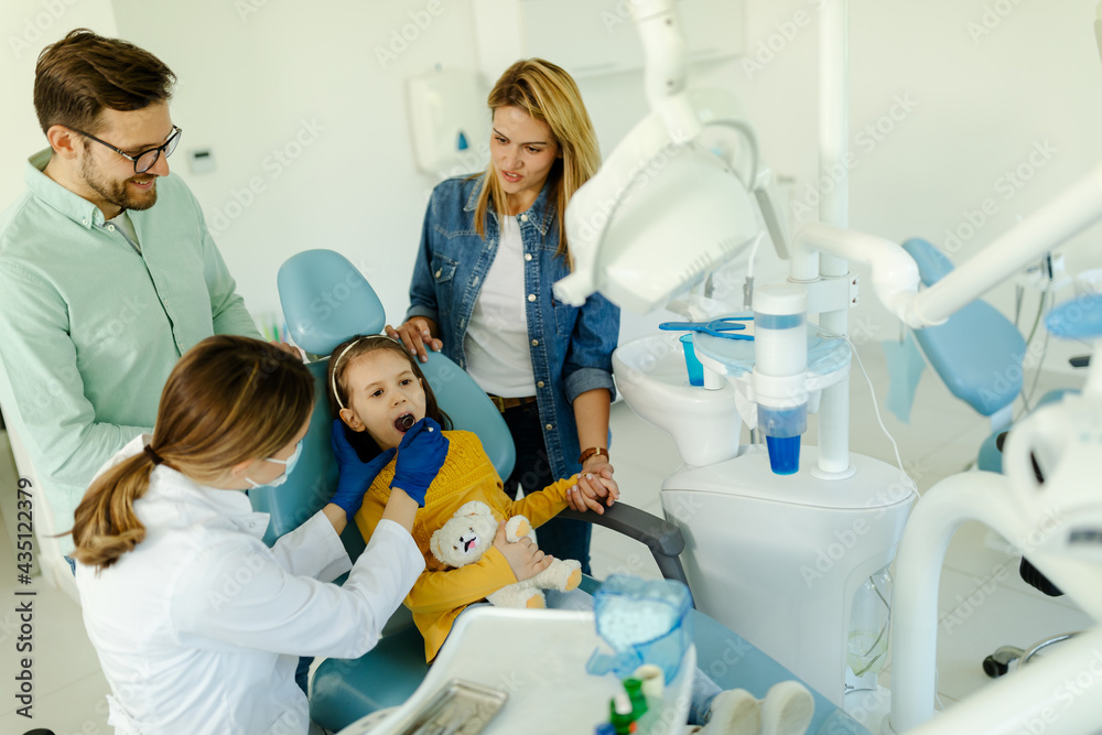 Female doctor with instruments in the hands looking girls teeth. Female doctor with instruments in the hands looking girls teeth.