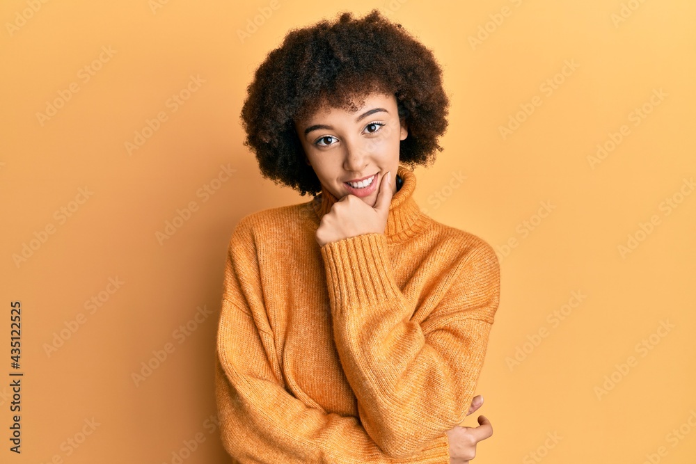 Young hispanic girl wearing wool winter sweater looking confident at the camera smiling with crossed arms and hand raised on chin. thinking positive.