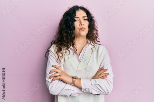 Young brunette woman with curly hair wearing casual clothes skeptic and nervous, disapproving expression on face with crossed arms. negative person.