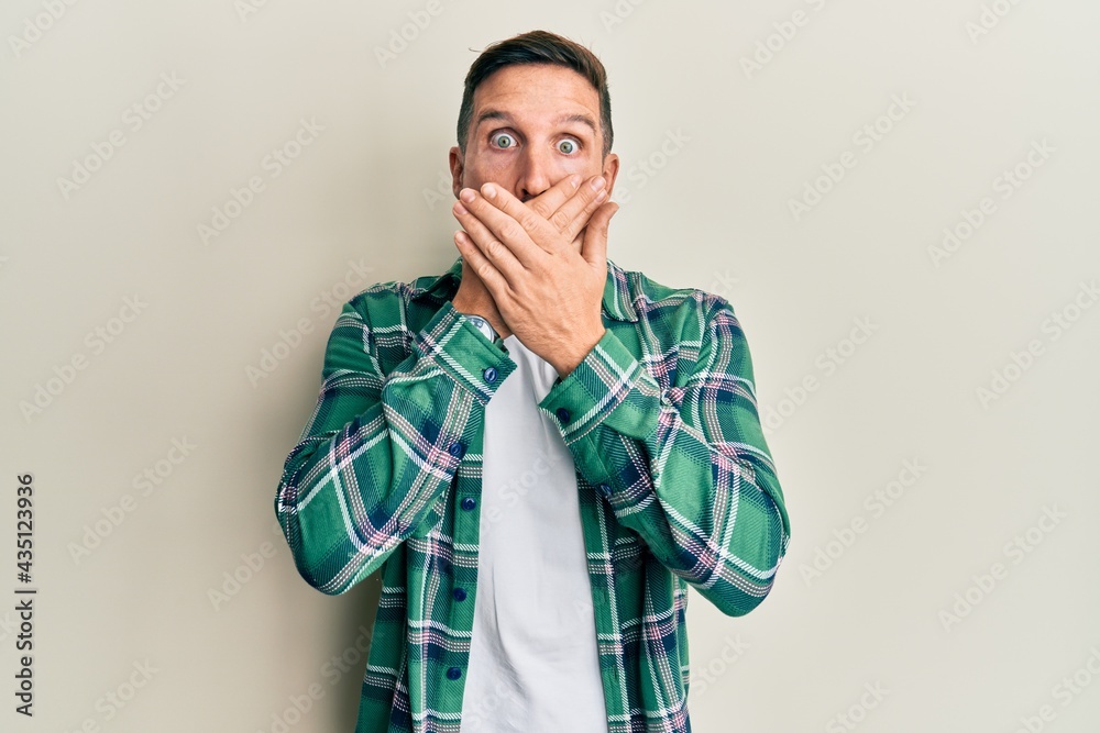 Handsome man with beard wearing casual clothes shocked covering mouth with hands for mistake. secret concept. Handsome man with beard wearing casual clothes shocked covering mouth with hands for mistake. secret concept.