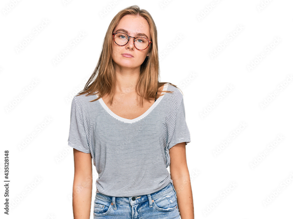 Obraz premium Beautiful young blonde woman wearing casual clothes and glasses relaxed with serious expression on face. simple and natural looking at the camera.