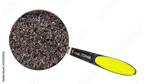 top view of niger seeds in measuring cup cutout photo