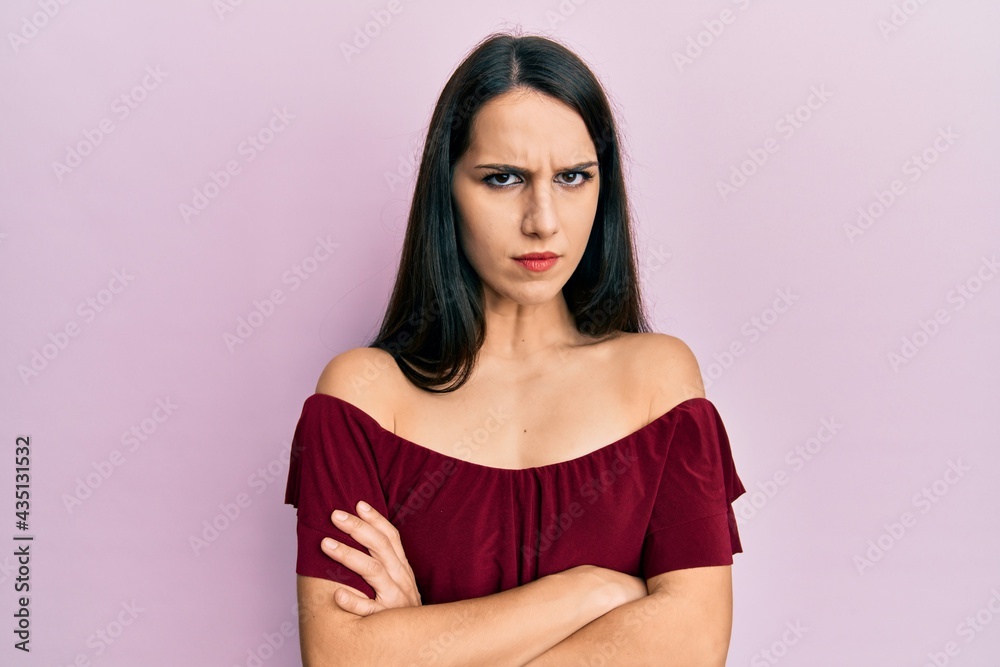 Young hispanic woman wearing casual clothes skeptic and nervous, disapproving expression on face with crossed arms. negative person. Young hispanic woman wearing casual clothes skeptic and nervous, disapproving expression on face with crossed arms. negative person.