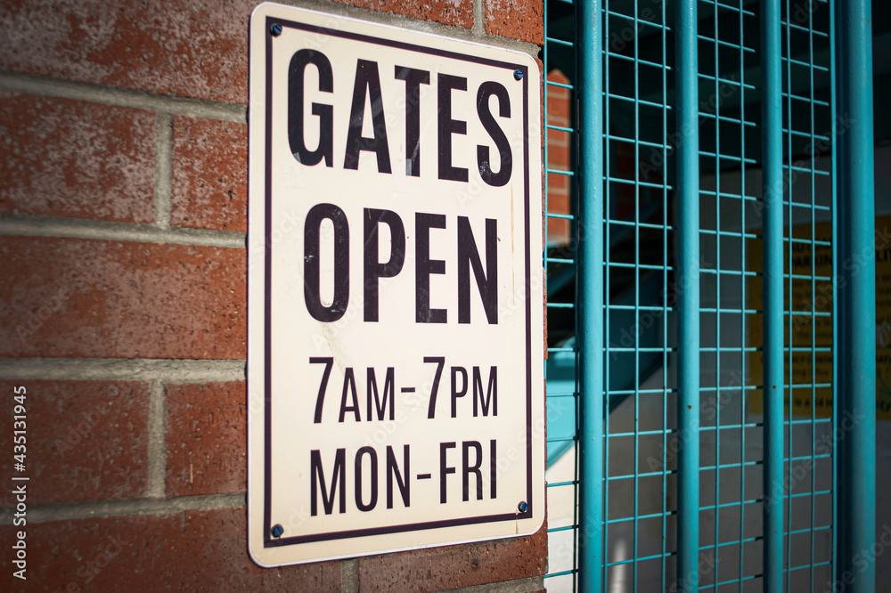 Obraz premium Gates open sign on old brick parking structure