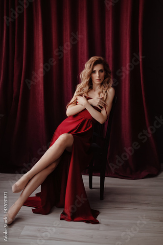 Gorgeous woman in a dark red dress. Natural colors. Trend of 2021 Natural female beauty. 
Girl in a playful and flirtatious mood