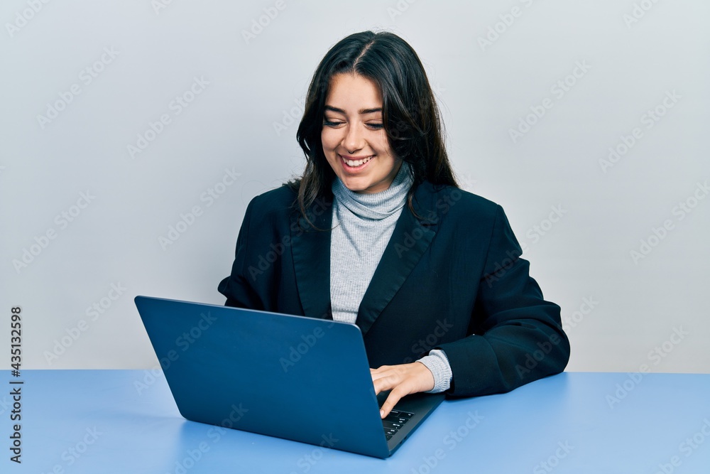 Beautiful hispanic woman working at the office with laptop smiling with a happy and cool smile on face. showing teeth. Beautiful hispanic woman working at the office with laptop smiling with a happy and cool smile on face. showing teeth.