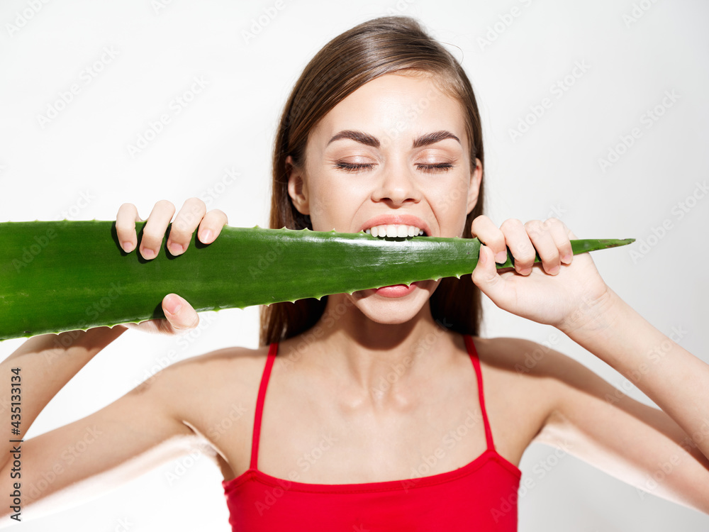 woman with white teeth biting aloe leaf and red t-shirt model cropped view woman with white teeth biting aloe leaf and red t-shirt model cropped view