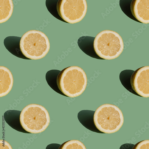 Fruit seamless pattern lemon on green pastel background. Trendy minimal sunlight summer concept.