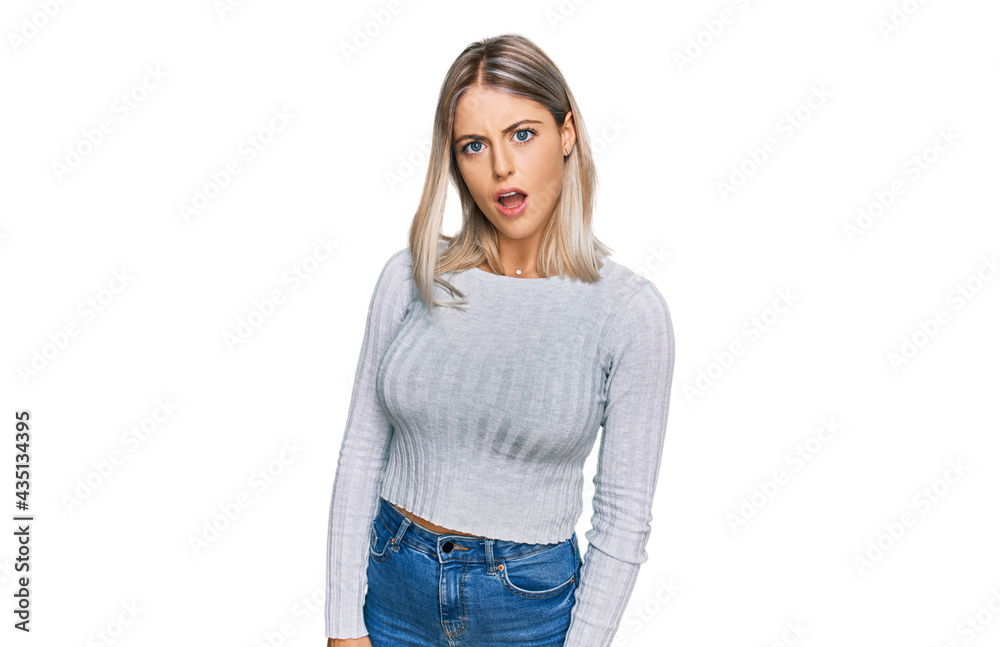 Beautiful blonde woman wearing casual clothes in shock face, looking skeptical and sarcastic, surprised with open mouth Beautiful blonde woman wearing casual clothes in shock face, looking skeptical and sarcastic, surprised with open mouth