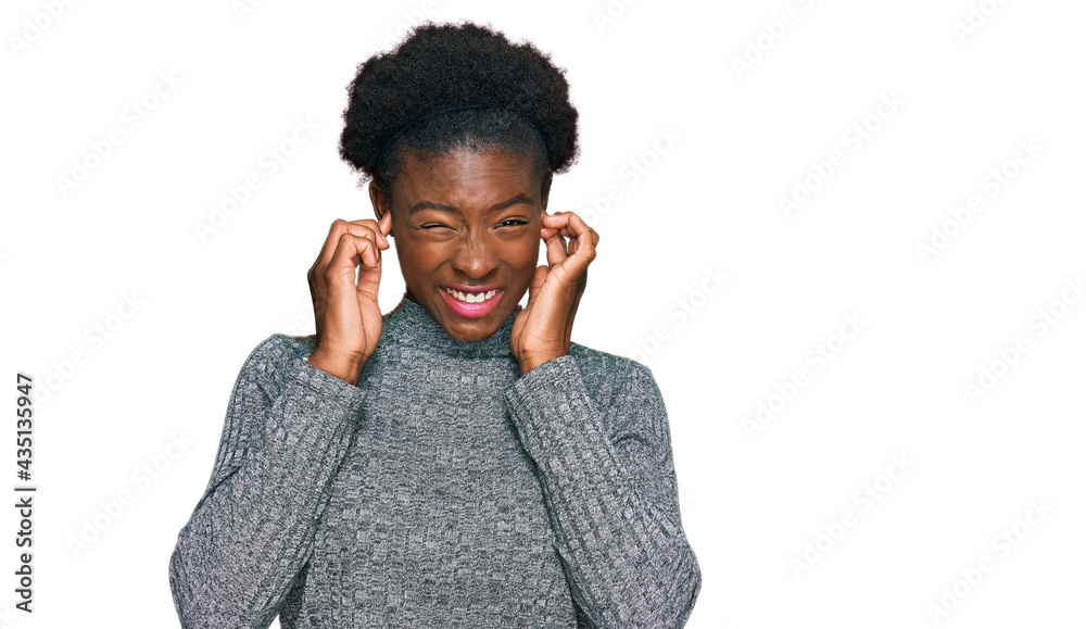 Young african american girl wearing casual clothes covering ears with fingers with annoyed expression for the noise of loud music. deaf concept. Young african american girl wearing casual clothes covering ears with fingers with annoyed expression for the noise of loud music. deaf concept.