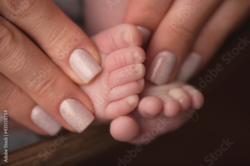 Children s feet in hold hands of mother and father. Mother  father and Child. Happy Family people concept.