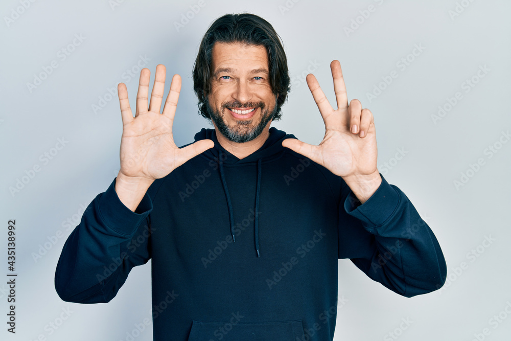 Middle age caucasian man wearing casual sweatshirt showing and pointing up with fingers number eight while smiling confident and happy. Middle age caucasian man wearing casual sweatshirt showing and pointing up with fingers number eight while smiling confident and happy.