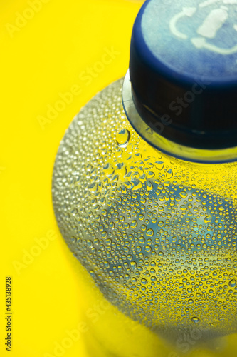 Mineral water plastic bottle with condensation drops, background
