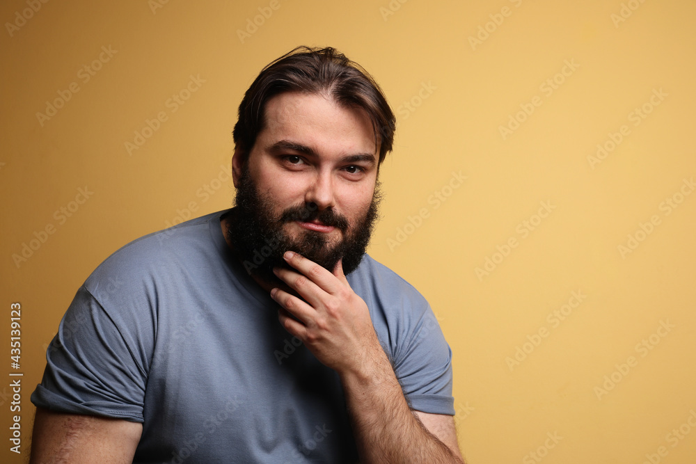 Hipster with beard, posing over yellow background. Isolated.