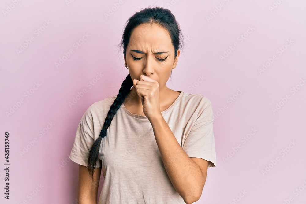 Young hispanic girl wearing casual white t shirt feeling unwell and coughing as symptom for cold or bronchitis. health care concept. Young hispanic girl wearing casual white t shirt feeling unwell and coughing as symptom for cold or bronchitis. health care concept.