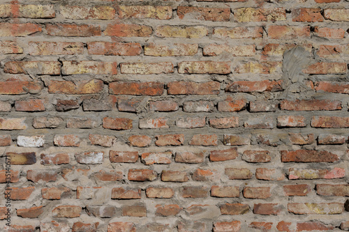 Old empty brick wall texture. Wall surface with plaster and paint problems. Grunge wall. Damaged wall. Copy space