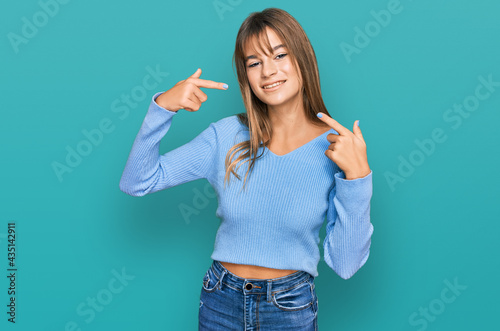 Teenager caucasian girl wearing casual clothes smiling cheerful showing and pointing with fingers teeth and mouth. dental health concept.