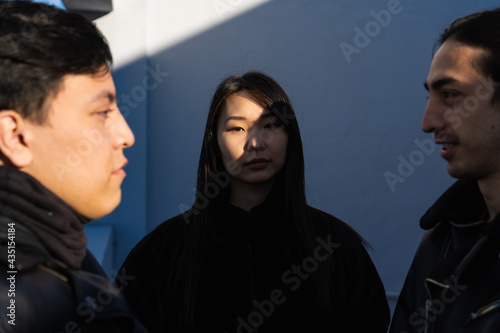 Foto photo of multiracial asian american woman with two latin men on either side, day