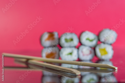 sushi with chopsticks on a red background