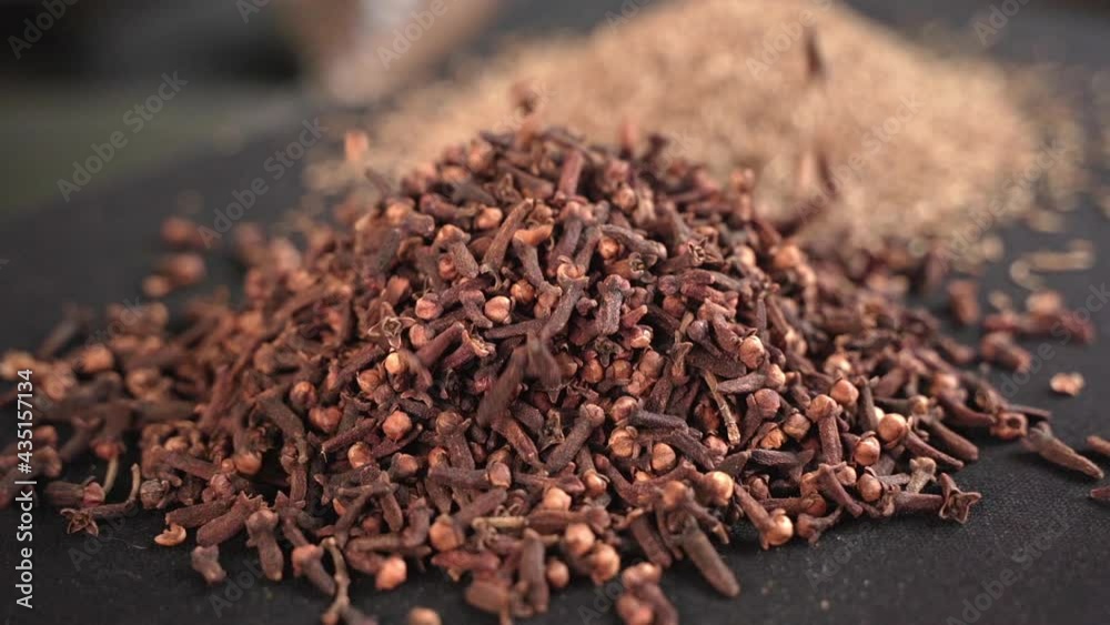 Close-up of cloves and spices with black background, industrial concept.