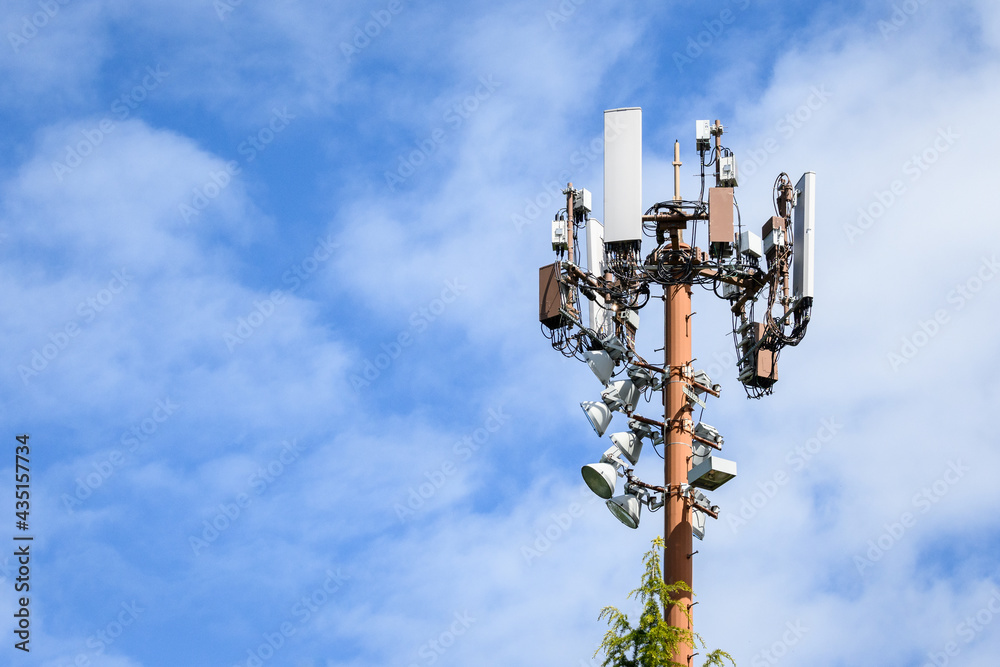 Mobility cell site, panel antennas on top of a light pole on a sunny day against a blue sky with white clouds
Mobility cell site, panel antennas on top of a light pole on a sunny day against a blue sky with white clouds