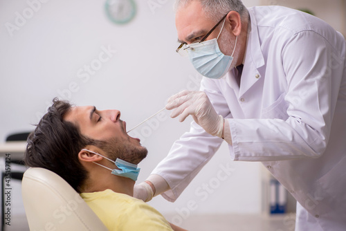 Young male patient visiting old male doctor otorhinolaryngologis
