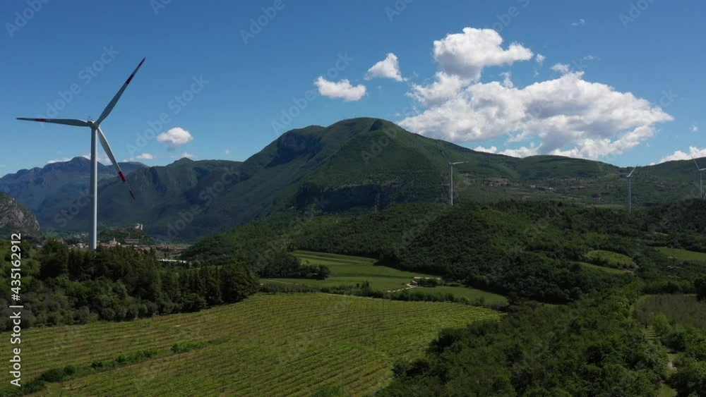 Wind generators in the mountains of Italy. Windmill surrounded by olive trees, vineyards, Alps. Wind turbine in Italy. Wind farm in the Alpine nature. Wind turbine in Affi, Lake Garda.