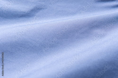 Closeup of rippled blue silk fabric, Blue fabric texture background, © kitthanes